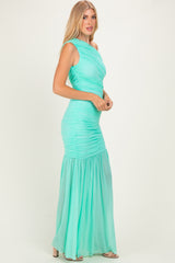 woman wearing a mint green ruched maxi dress with a fitted bodice and flowing skirt
