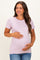 woman wearing a light purple maternity top and holding her baby bump