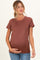 woman wearing a rust brown short sleeve maternity top and holding her baby bump