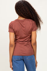woman wearing a brown short sleeve top and blue jeans, viewed from the back