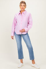 woman wearing a pink and white striped maternity button-up shirt and blue jeans, displaying her baby bump