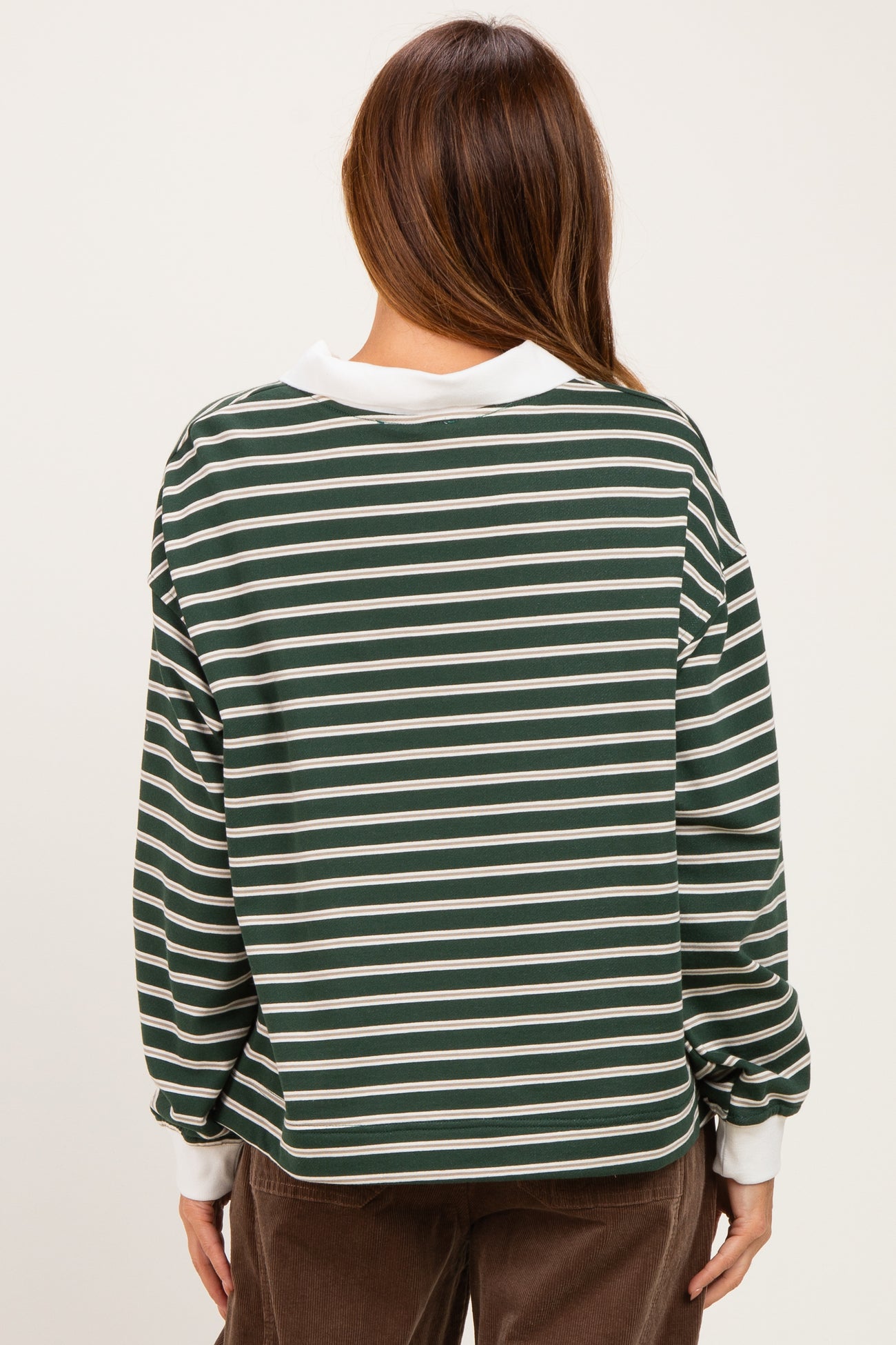 woman wearing a green and white striped long sleeve top with a relaxed fit and contrasting collar