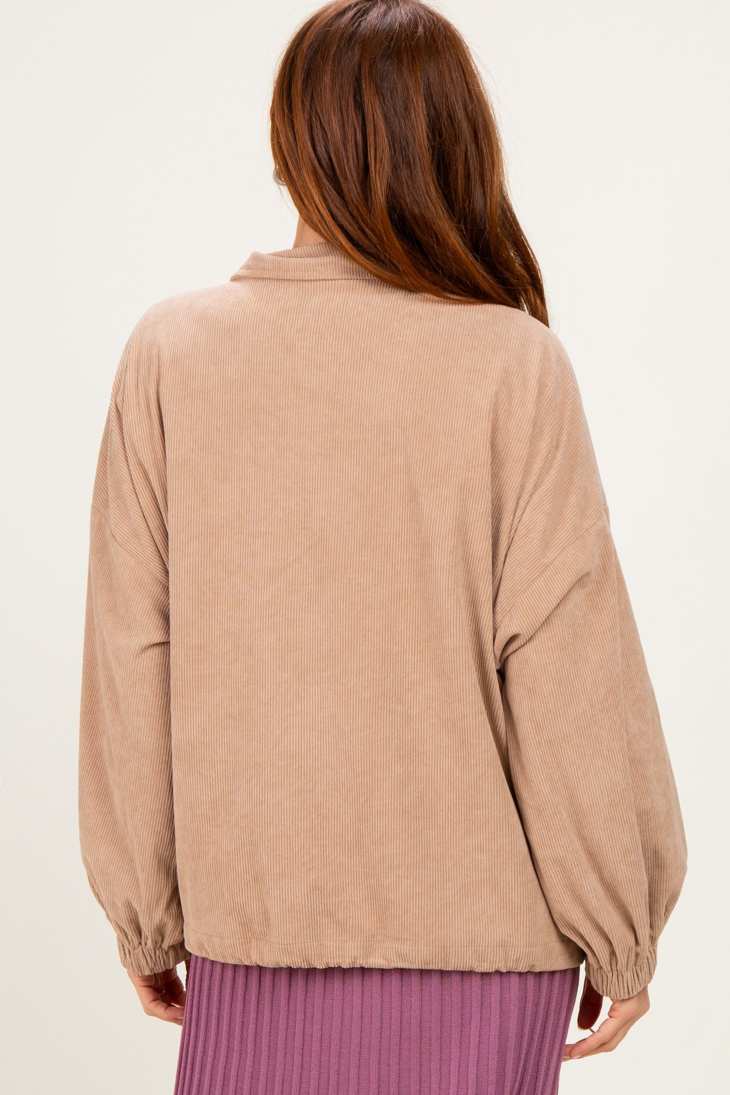 woman wearing a tan corduroy oversized jacket with balloon sleeves, viewed from the back
