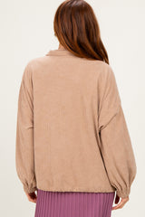 woman wearing a tan corduroy oversized jacket with balloon sleeves, viewed from the back
