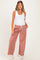woman wearing a white tank top and red checkered maternity pants with a side pocket and drawstring waist, showing baby bump