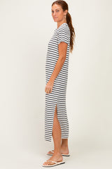 woman wearing a black and white striped maxi dress with short sleeves and side slits, standing sideways