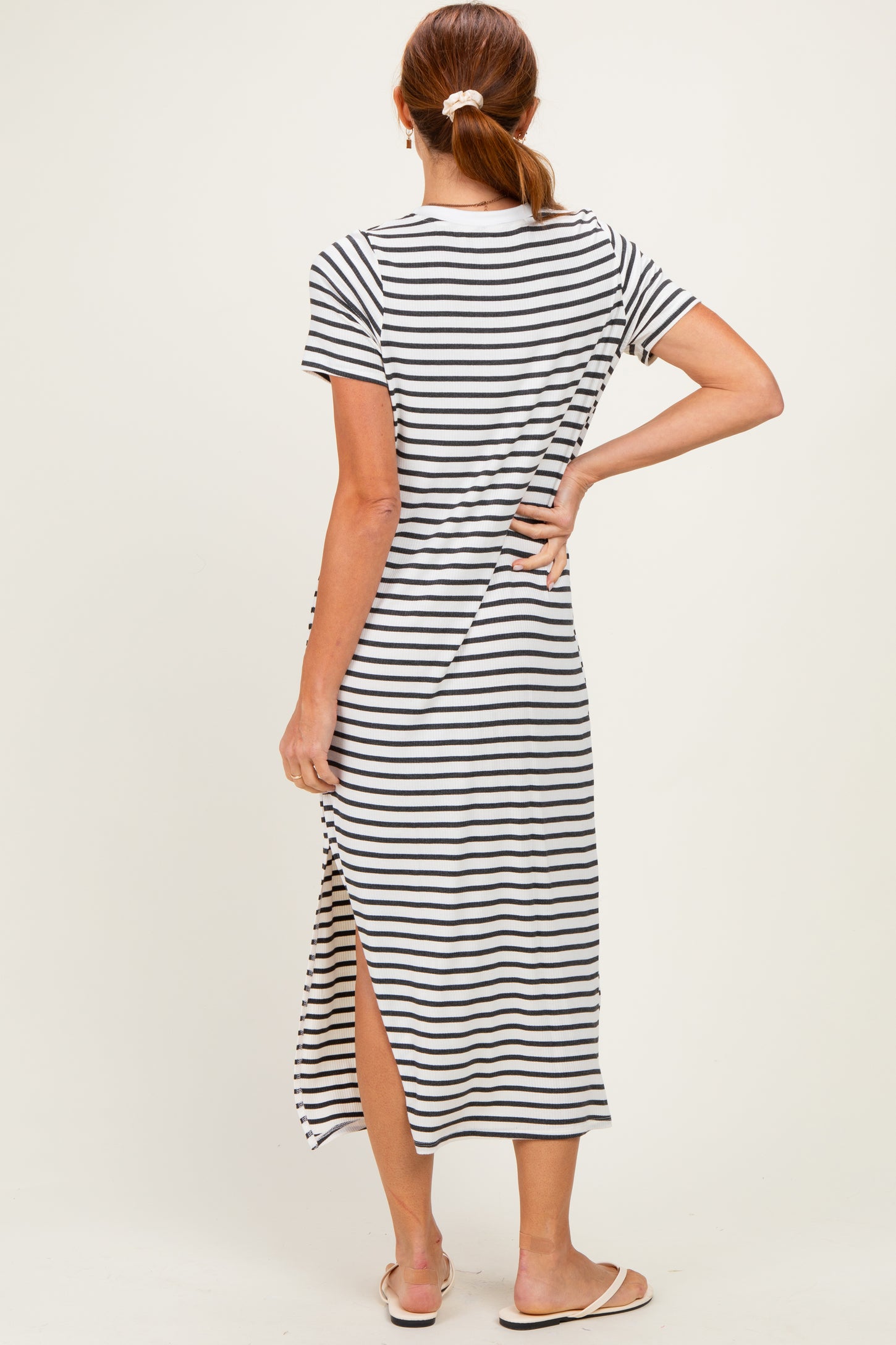 woman wearing a black and white striped maxi dress with short sleeves and side slit