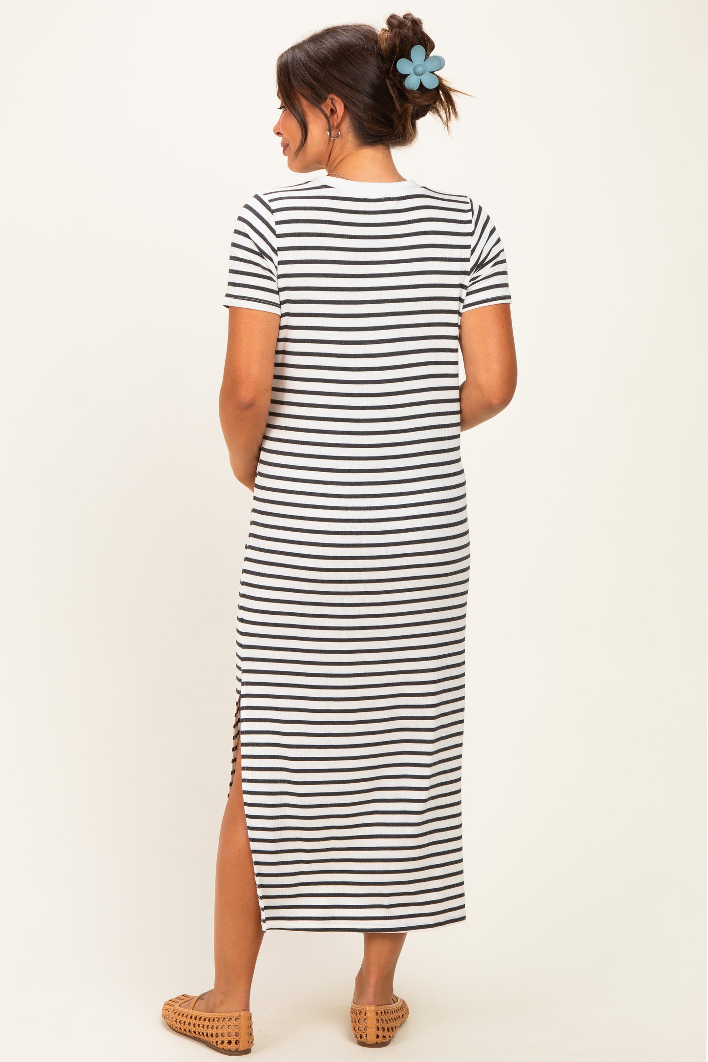 woman wearing a striped maternity maxi dress with short sleeves and a side slit, showing a baby bump