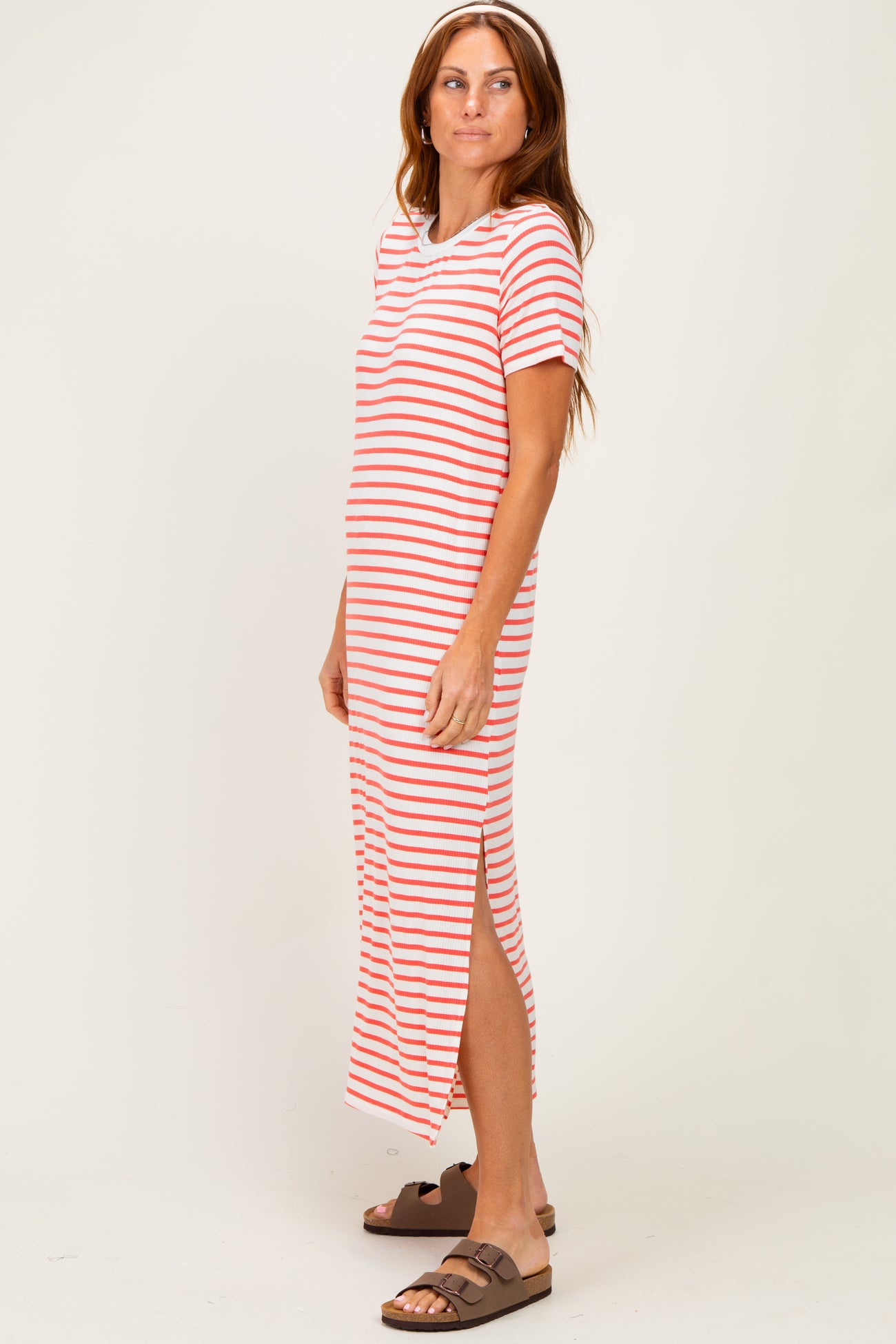 woman wearing a red and white striped maxi dress with short sleeves and side slits
