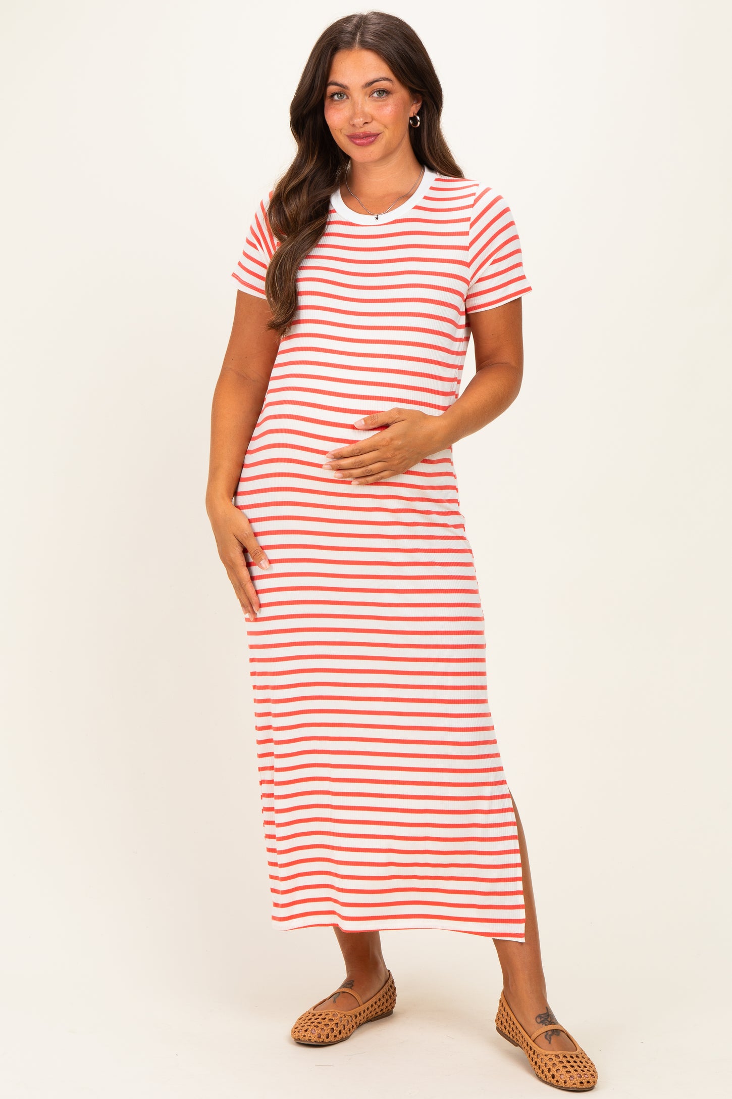 woman wearing a red and white striped maternity maxi dress and holding her baby bump