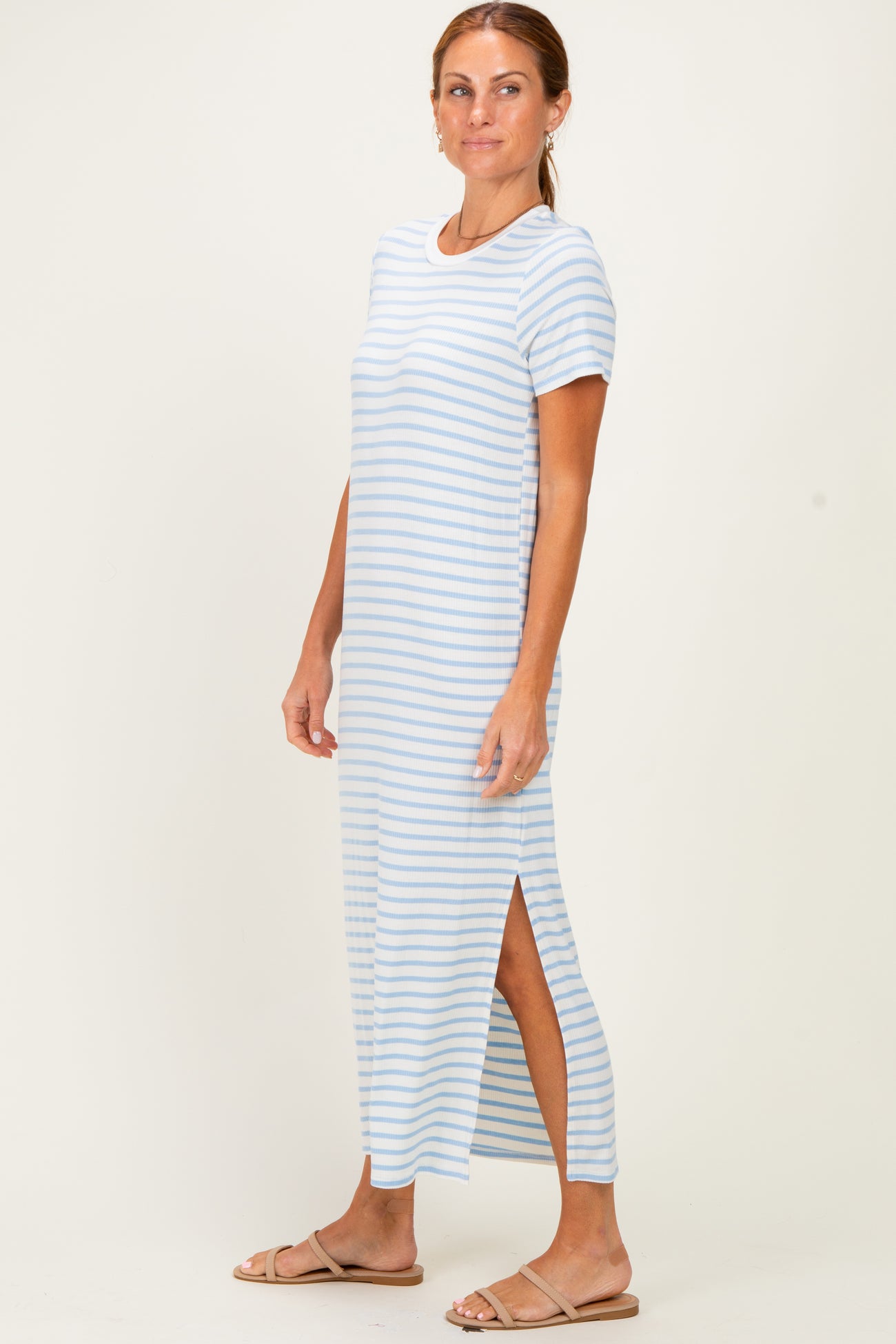 woman wearing a light blue and white striped maxi dress with side slits and short sleeves