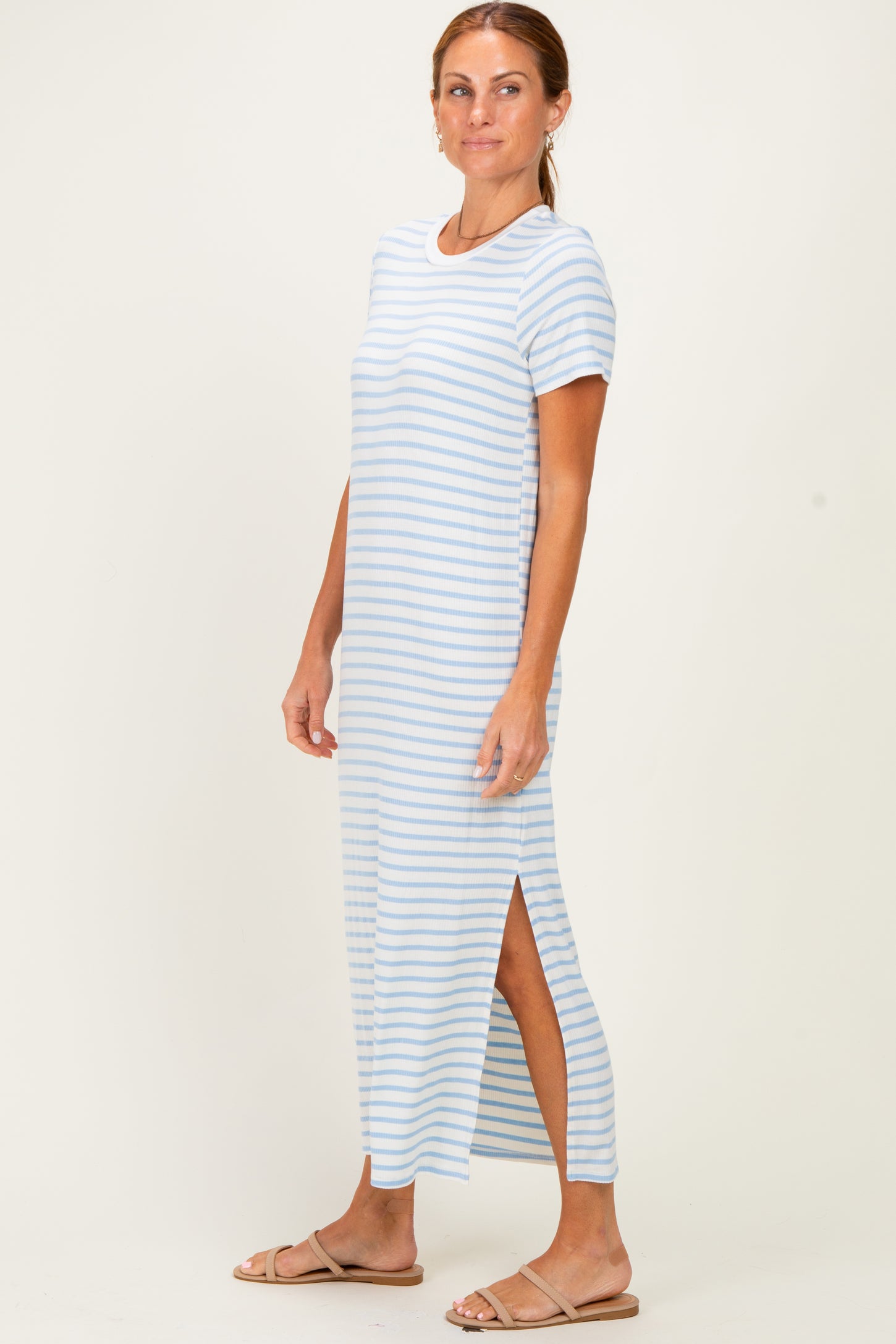 woman wearing a light blue and white striped maxi dress with side slits and short sleeves