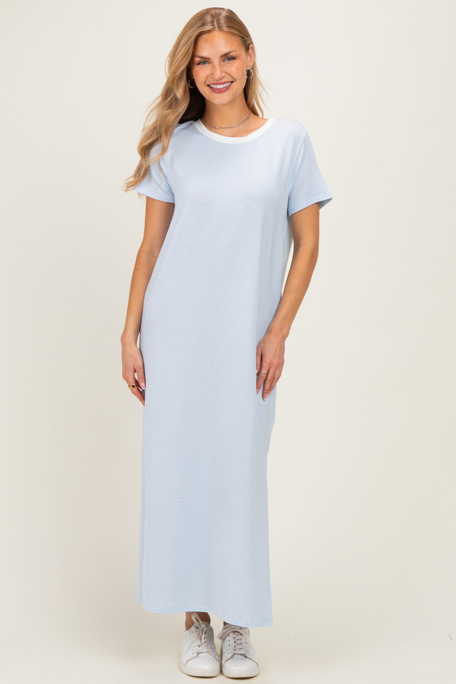 woman wearing a light blue short sleeve maxi dress paired with white sneakers