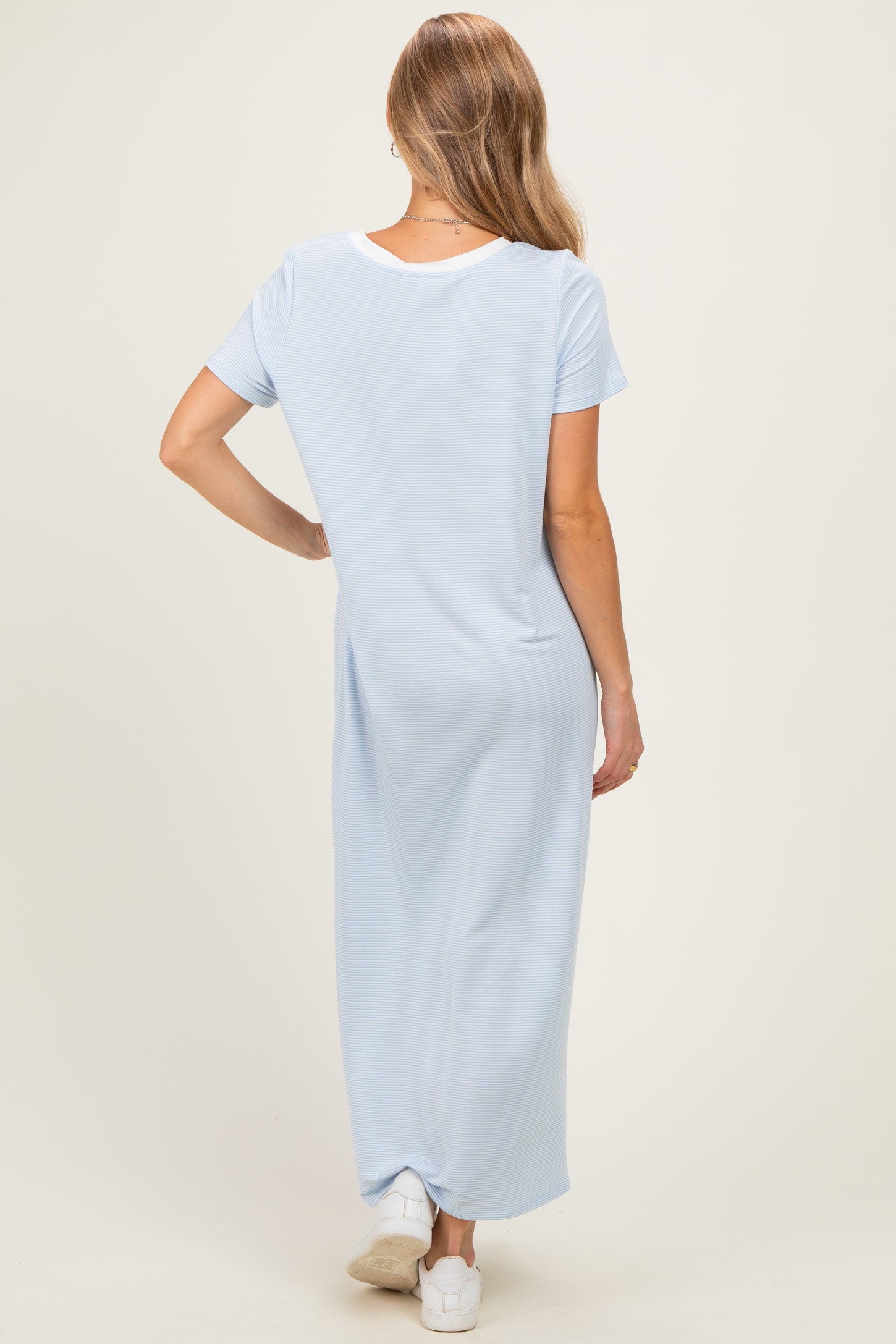 woman wearing a light blue short sleeve maxi dress, view from the back