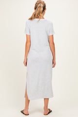 woman wearing a gray short sleeve maxi maternity dress with a side slit, viewed from the back