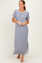 woman wearing a gray maxi dress with short sleeves and a white neckline, standing against a light background