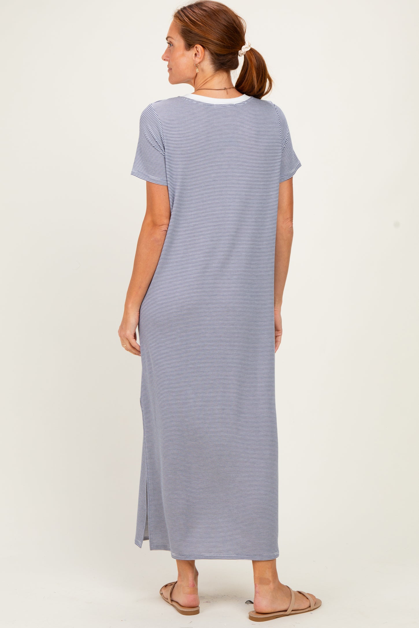 woman wearing a long light blue maxi dress with short sleeves and a slit, viewed from the back