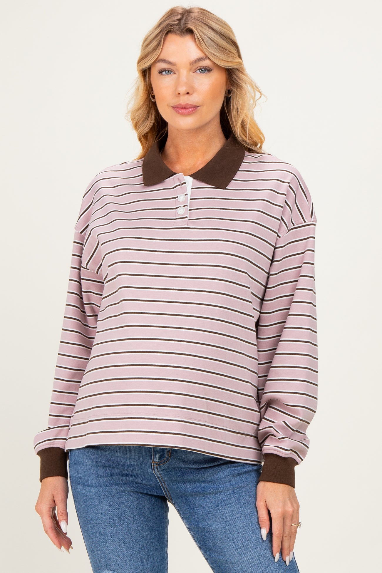 woman wearing a pink and brown striped maternity polo sweatshirt with a collar and long sleeves