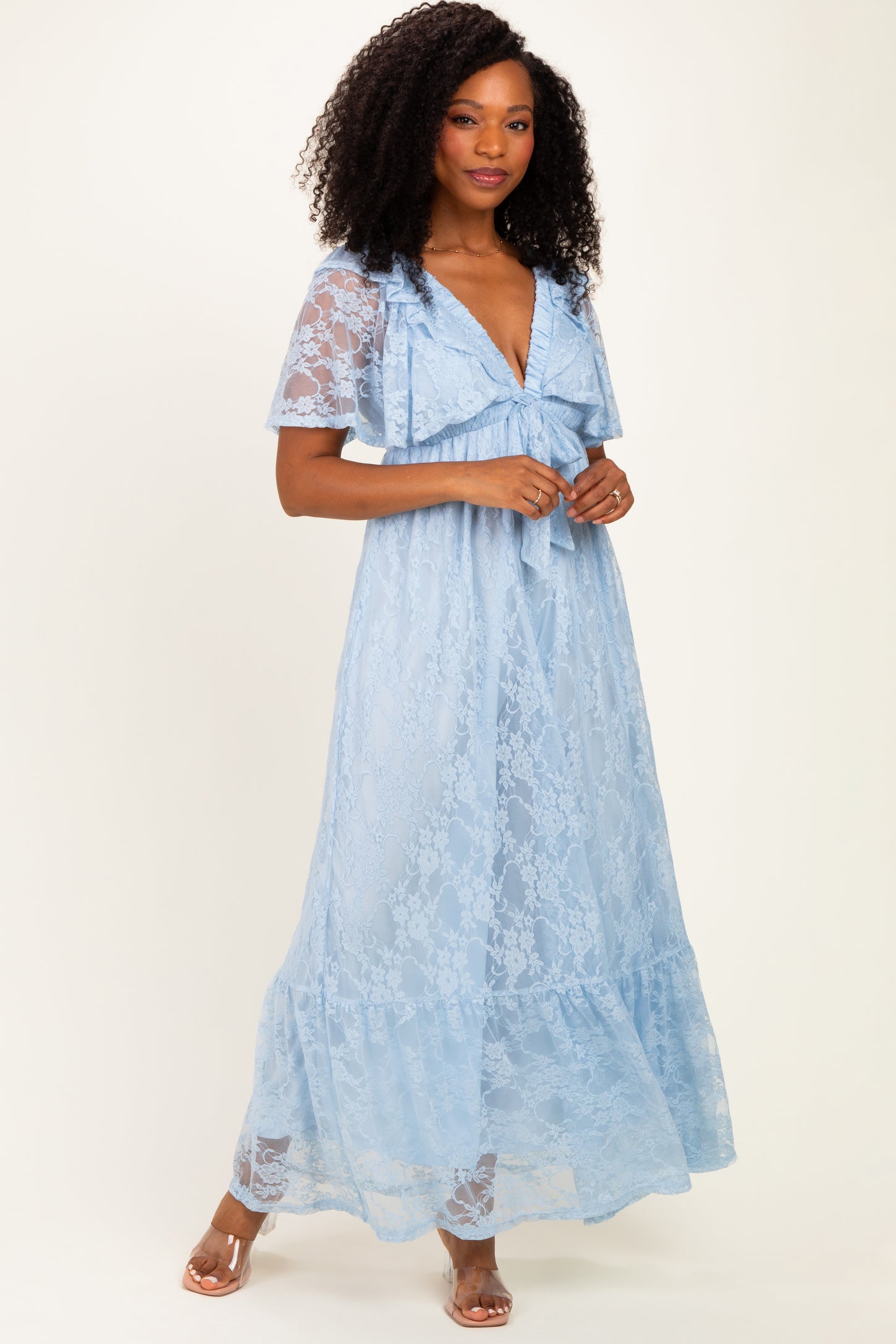 woman wearing a light blue lace maxi dress with short sleeves and a ruffled neckline