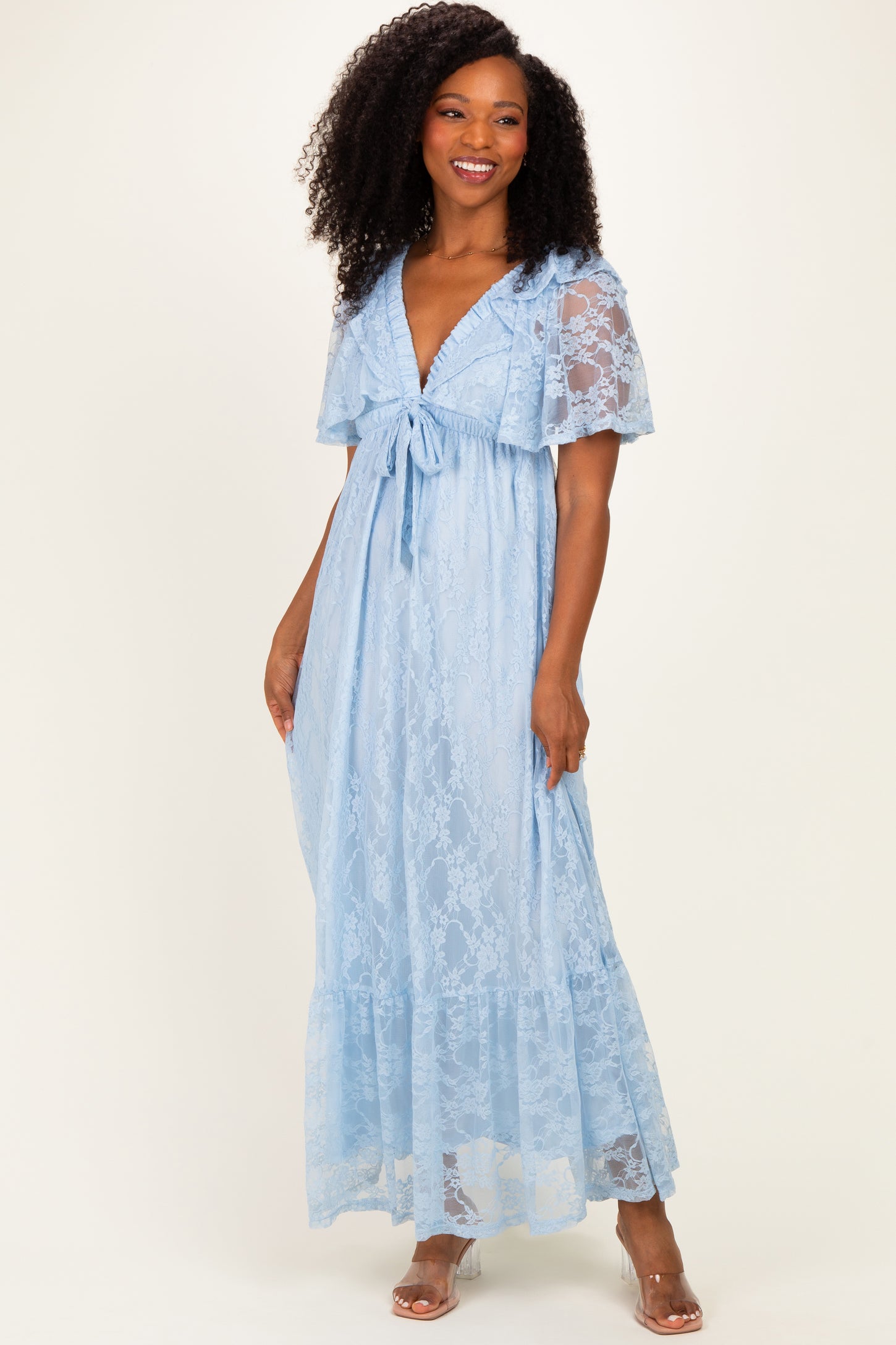 woman wearing a light blue lace maxi dress with flutter sleeves and a tied waist