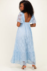 woman wearing a light blue lace maxi dress with a backless design and flared sleeves, shown from the back