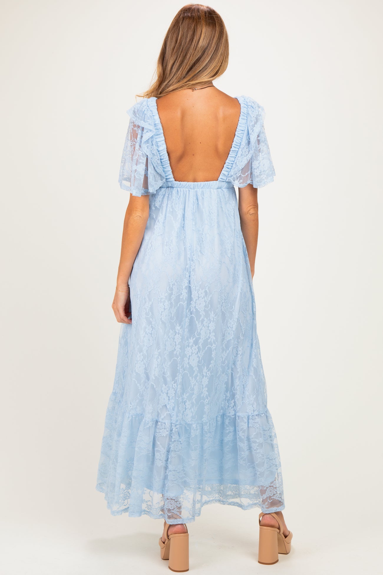 woman wearing a light blue lace maternity maxi dress with a ruffled back and short sleeves