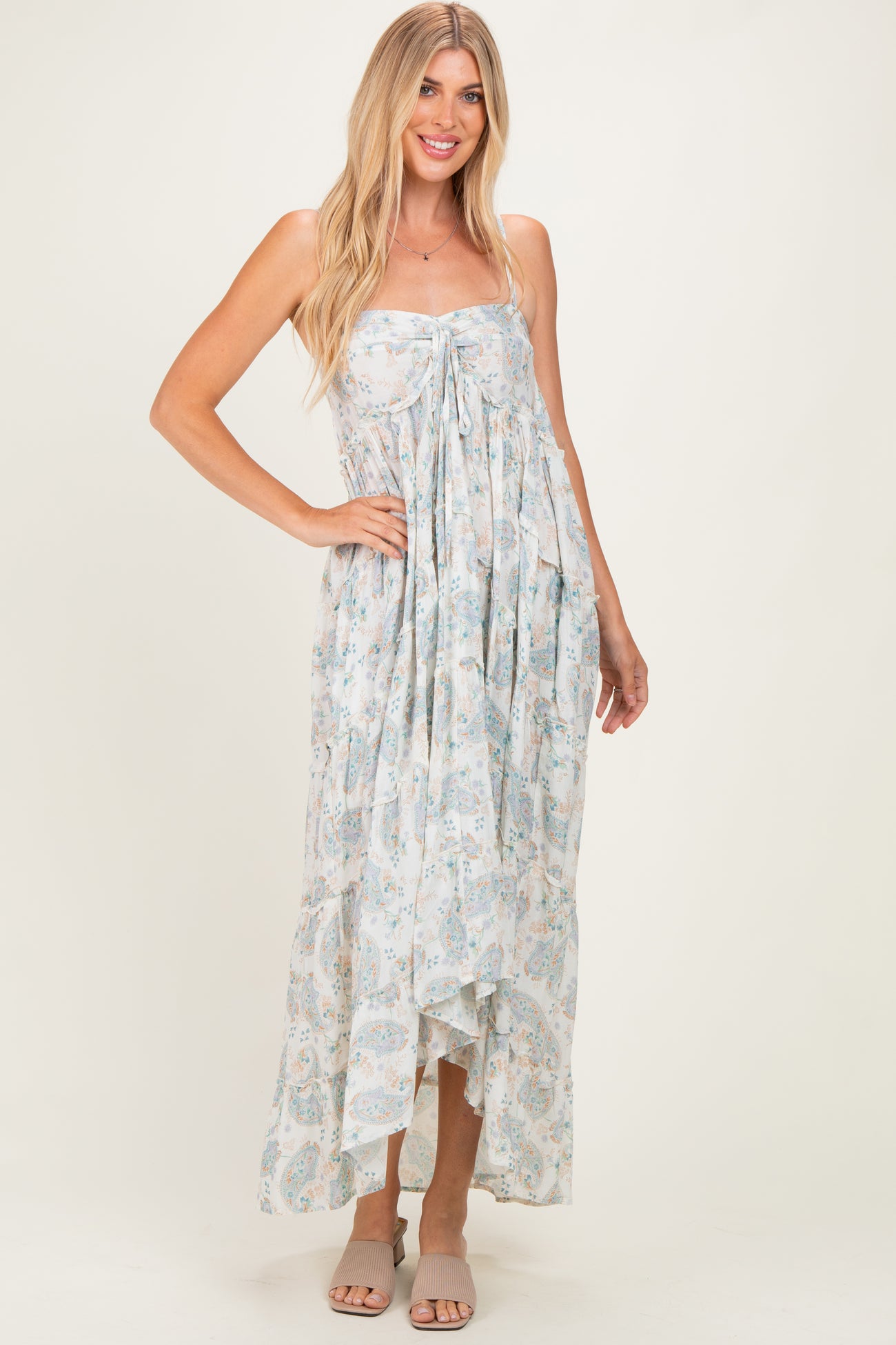 woman wearing a light blue floral maxi dress with a tie front and high-low hemline