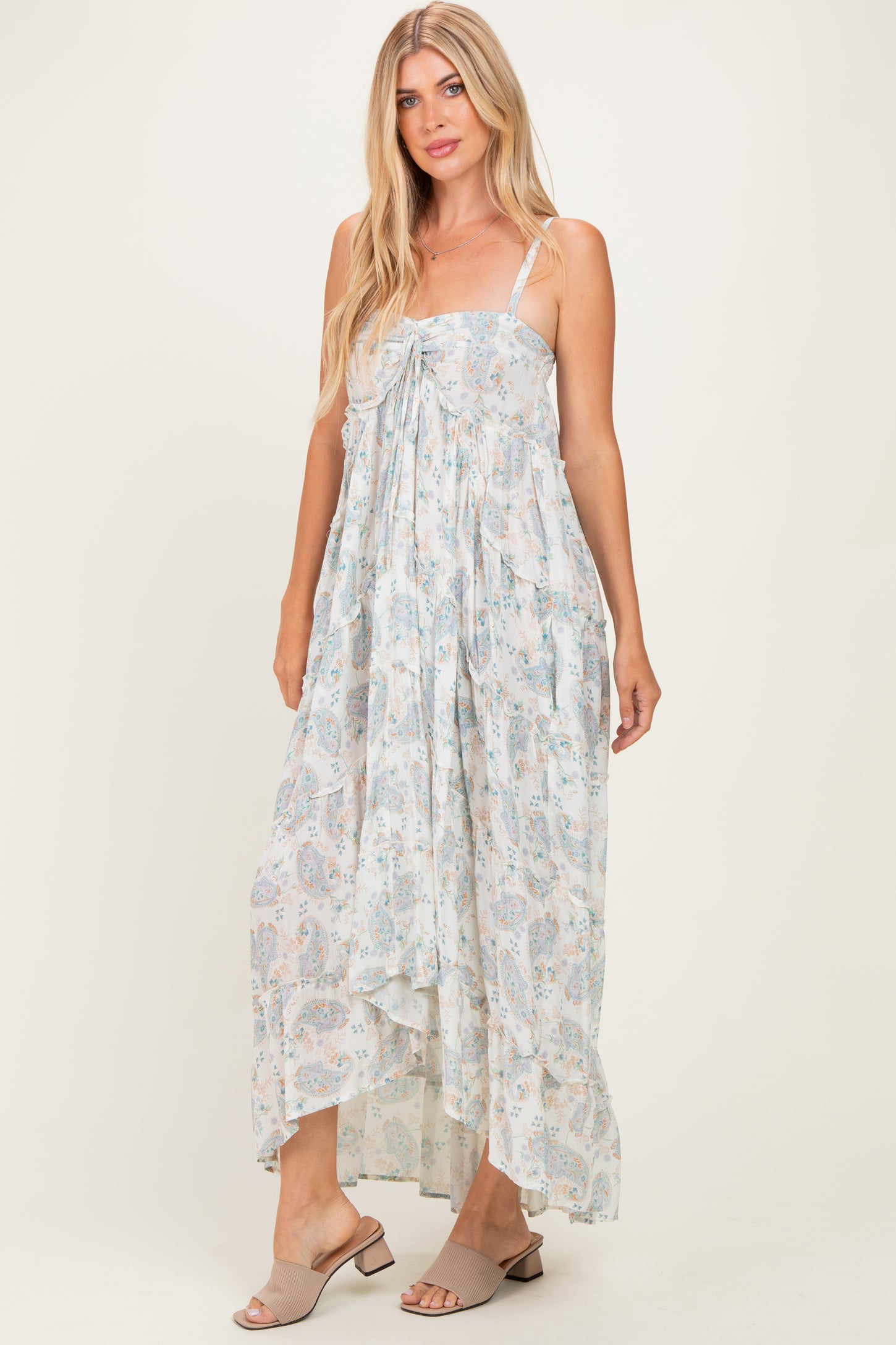 woman wearing a flowy white floral maxi dress with tie front detail and spaghetti straps