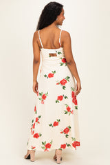 woman wearing a floral print cream maternity maxi dress with adjustable straps and a keyhole back design