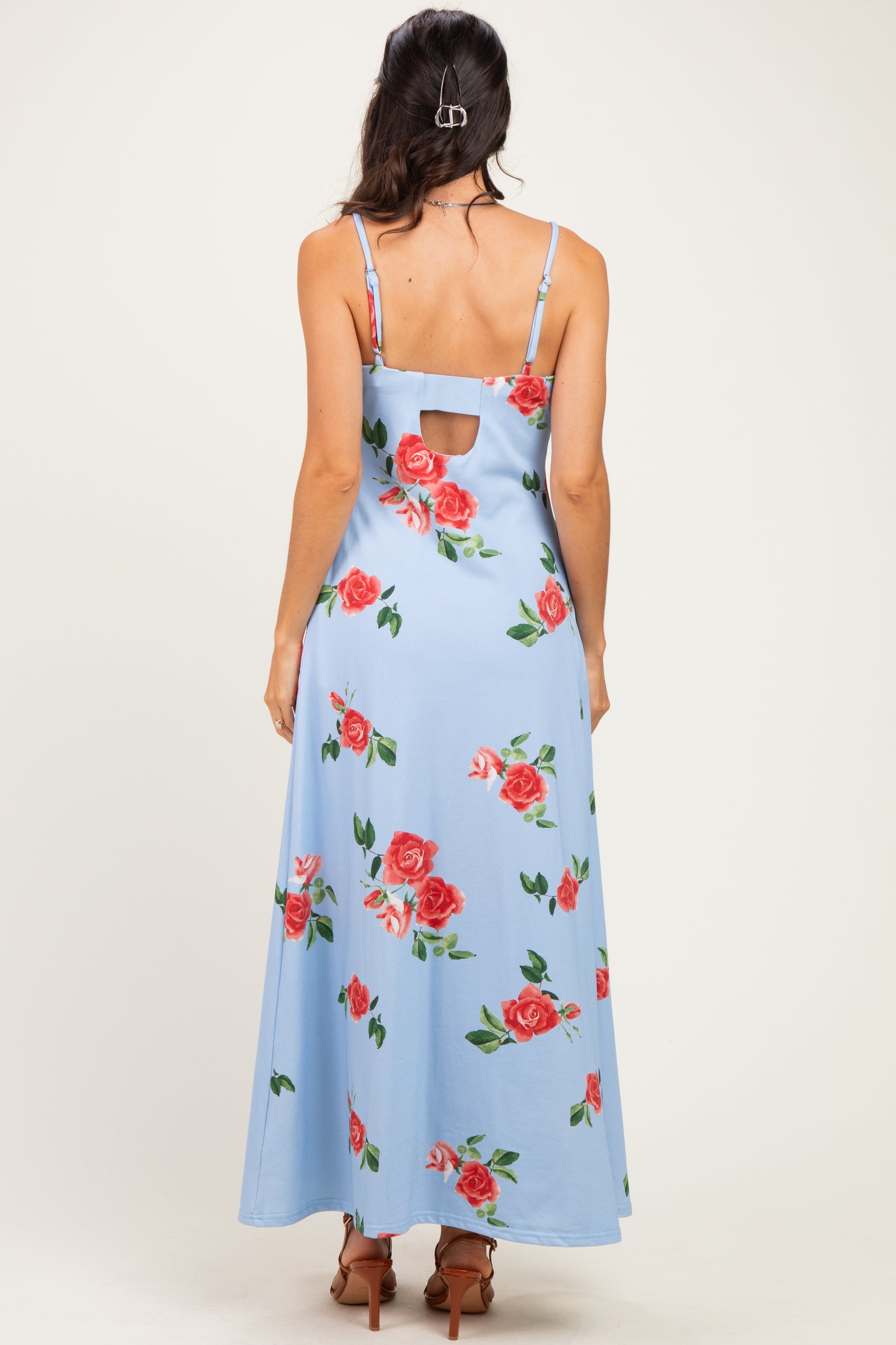 woman wearing a light blue floral maxi dress with a keyhole back and adjustable straps