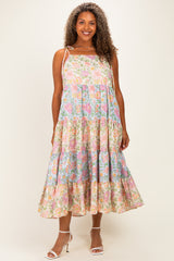 woman wearing a floral midi dress with pink and blue patterns, featuring tiered ruffles and adjustable straps
