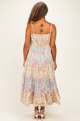 woman wearing a floral plus size maxi dress with a smocked bodice and ruffled hem, shown from the back