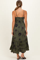 woman wearing a green floral maternity maxi dress with a tiered skirt and adjustable spaghetti straps, showing her back
