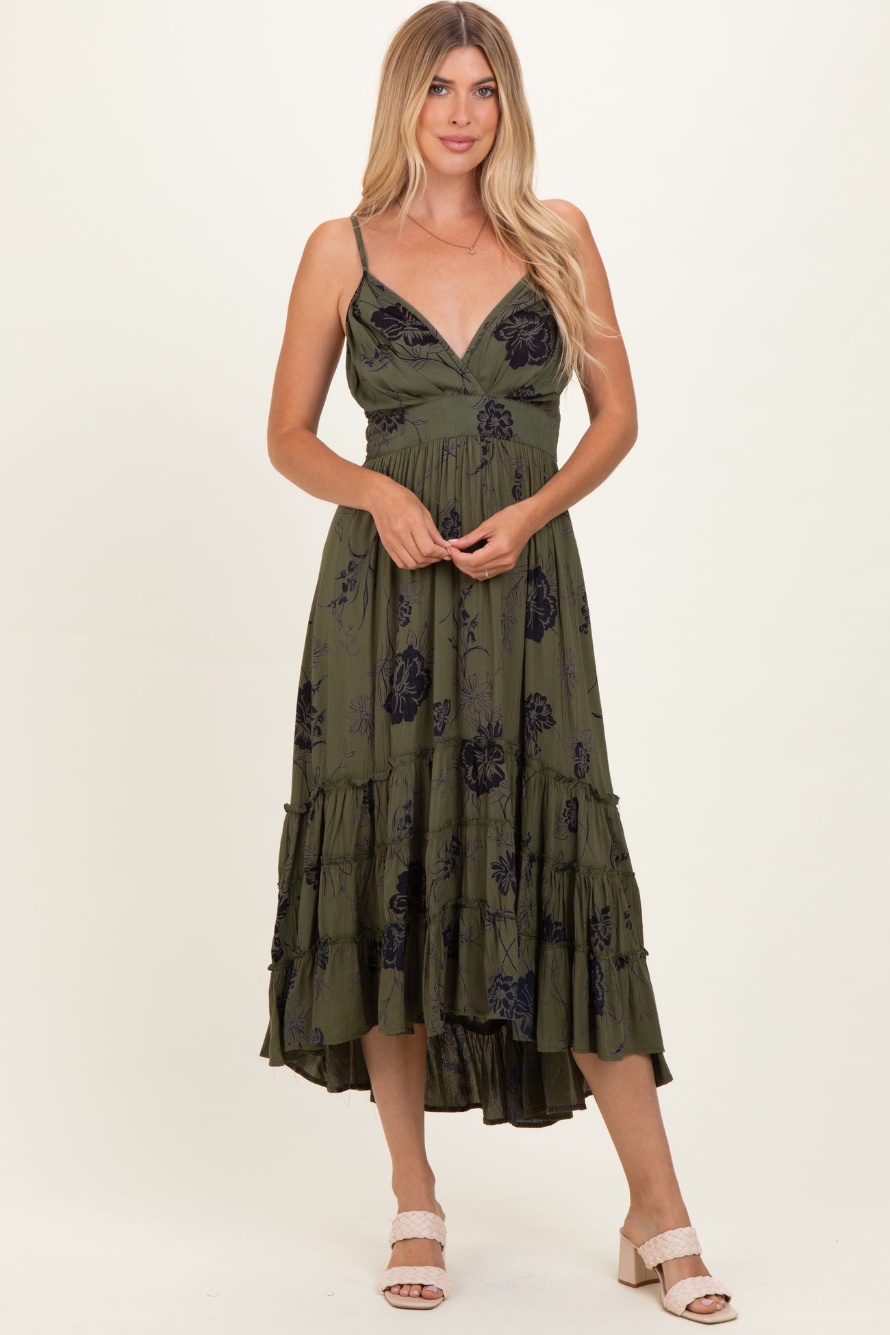 woman wearing a green floral print midi dress with spaghetti straps and ruffle details