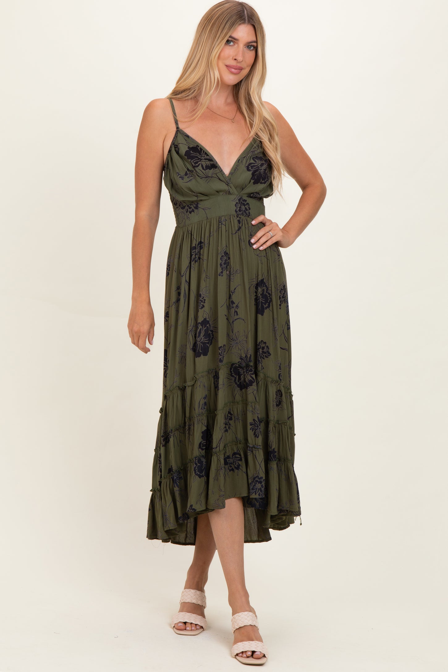 woman wearing an olive green floral maxi dress with a v-neckline and tiered skirt