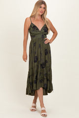 woman wearing an olive green floral maxi dress with a v-neckline and tiered skirt