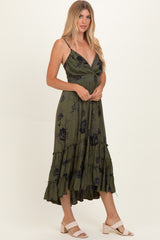 woman wearing an olive green floral print midi dress with spaghetti straps and ruffle hem