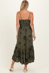 woman wearing an olive green floral maxi dress with ruffled layers and adjustable spaghetti straps, seen from the back