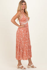 woman wearing a peach floral print maxi dress with spaghetti straps and a tiered skirt