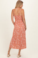 woman wearing an orange floral maxi dress with a smocked back and adjustable straps