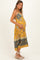 woman wearing a yellow floral maternity maxi dress and holding her baby bump