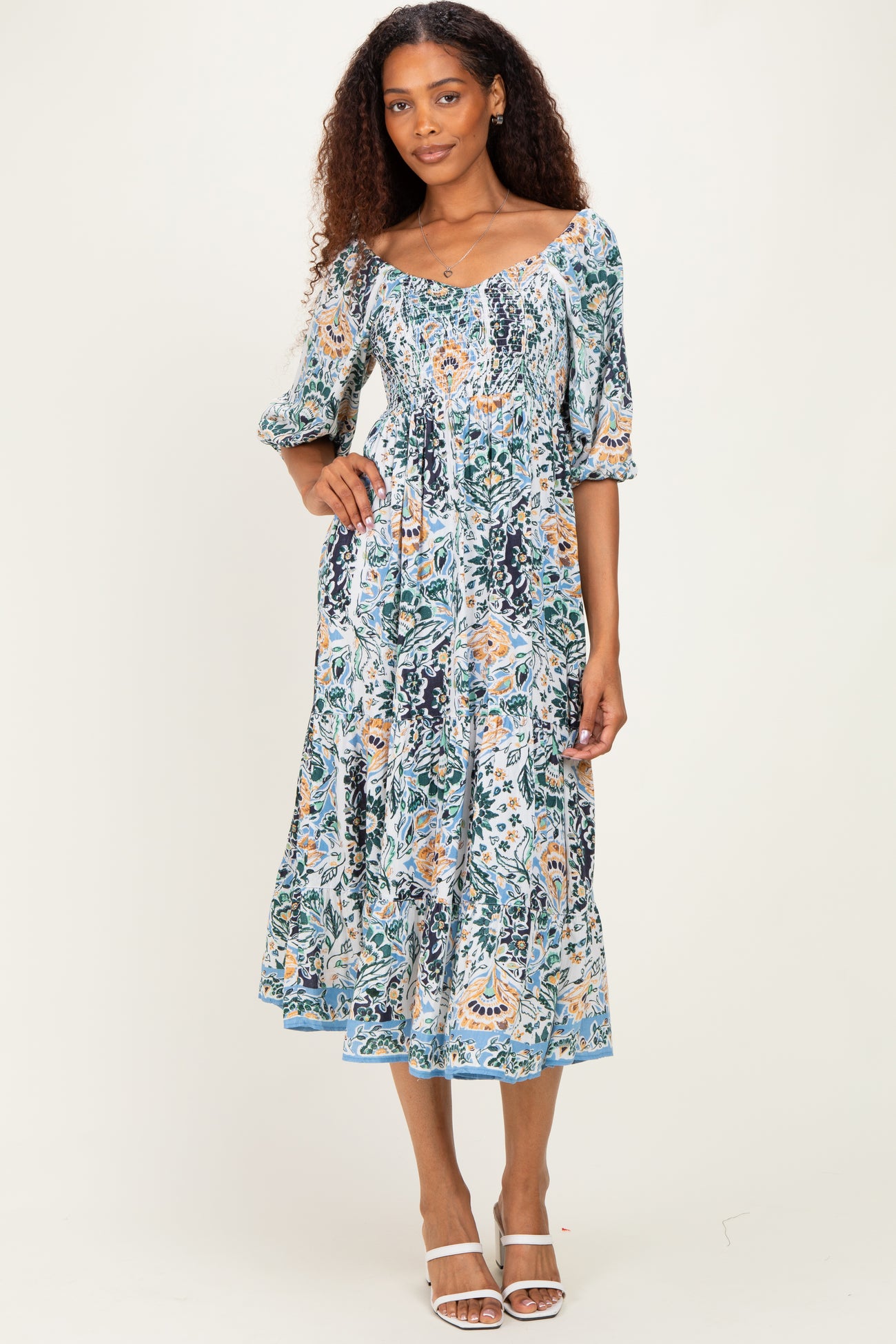 woman wearing a floral print maxi dress with puff sleeves and a smocked bodice