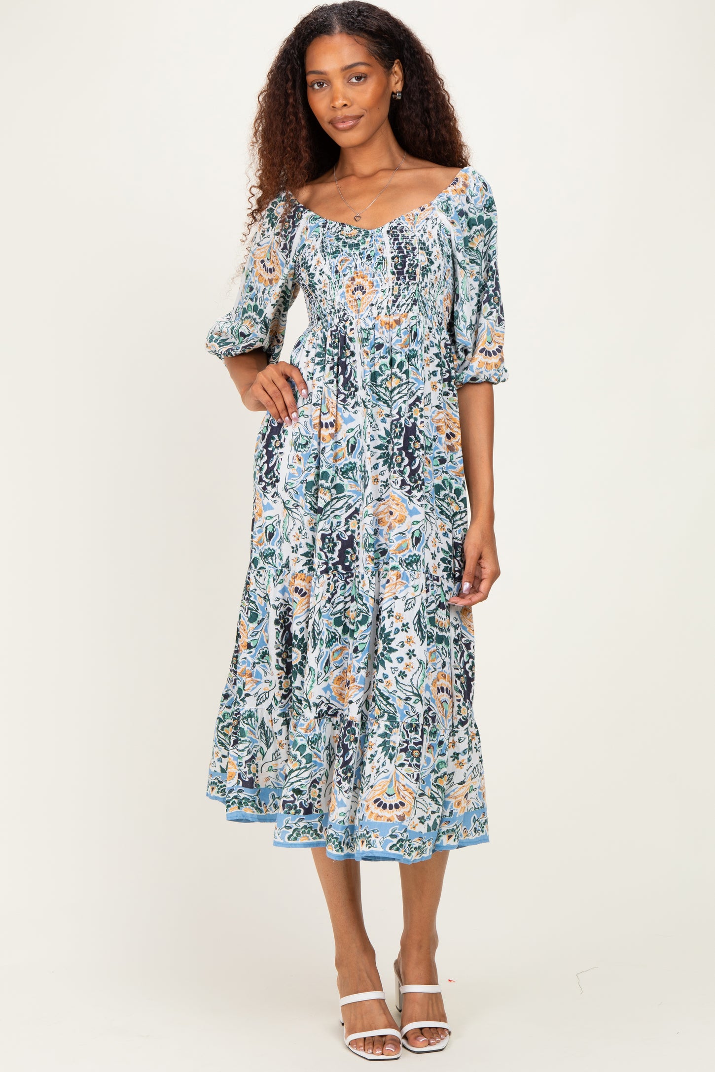 woman wearing a floral print maxi dress with puff sleeves and a smocked bodice