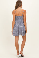 woman wearing a navy blue floral maternity dress with a smocked back and adjustable straps