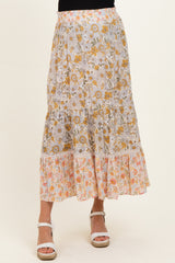 woman wearing a floral maternity maxi skirt with tiers in yellow and orange hues