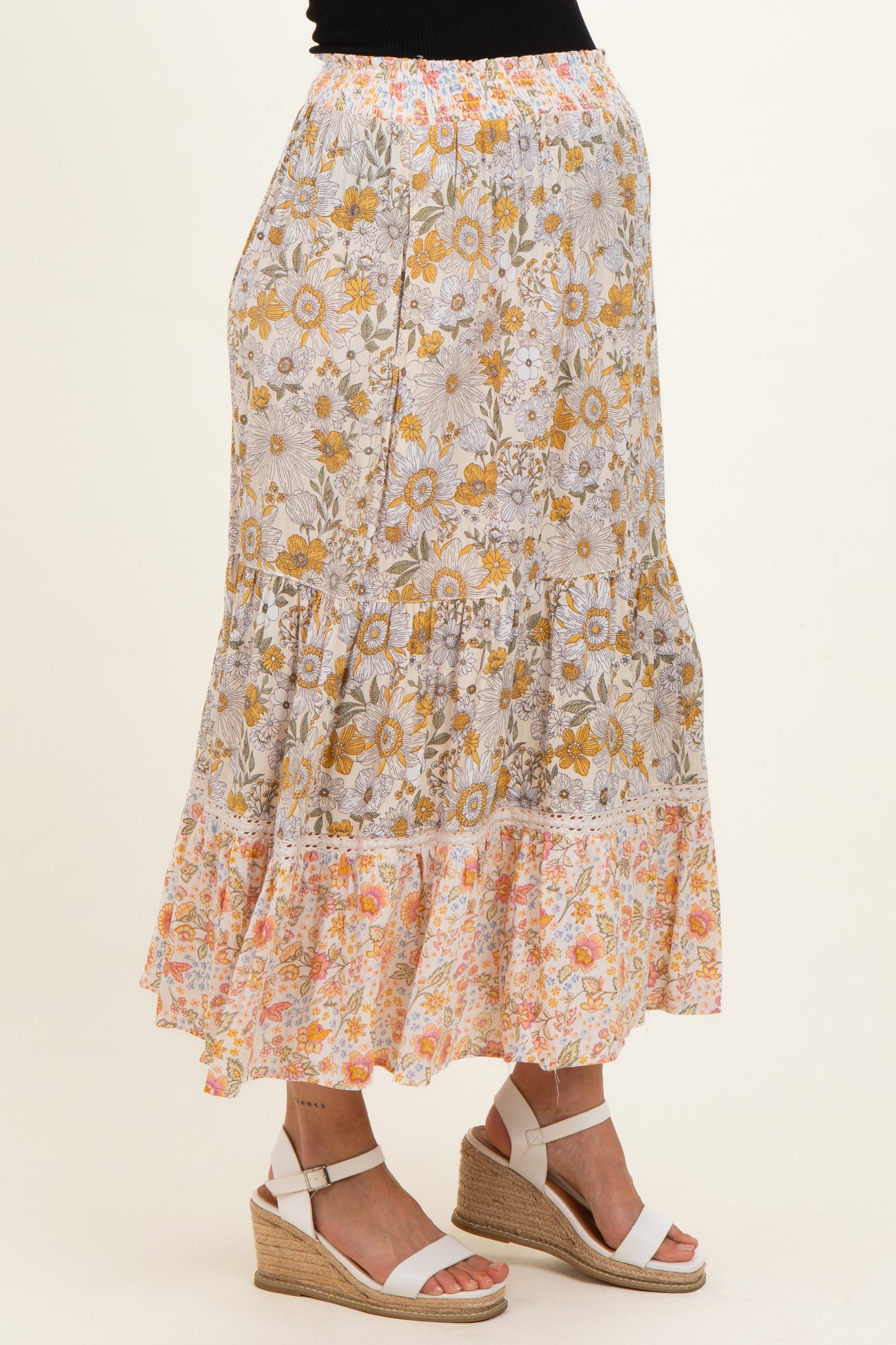 woman wearing a floral maternity maxi skirt with a tiered design and an elastic waistband