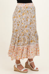 woman wearing a floral maternity maxi skirt with a tiered design and an elastic waistband