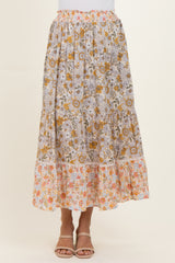 woman wearing a tiered floral maxi skirt with a pastel color palette and an elastic waistband