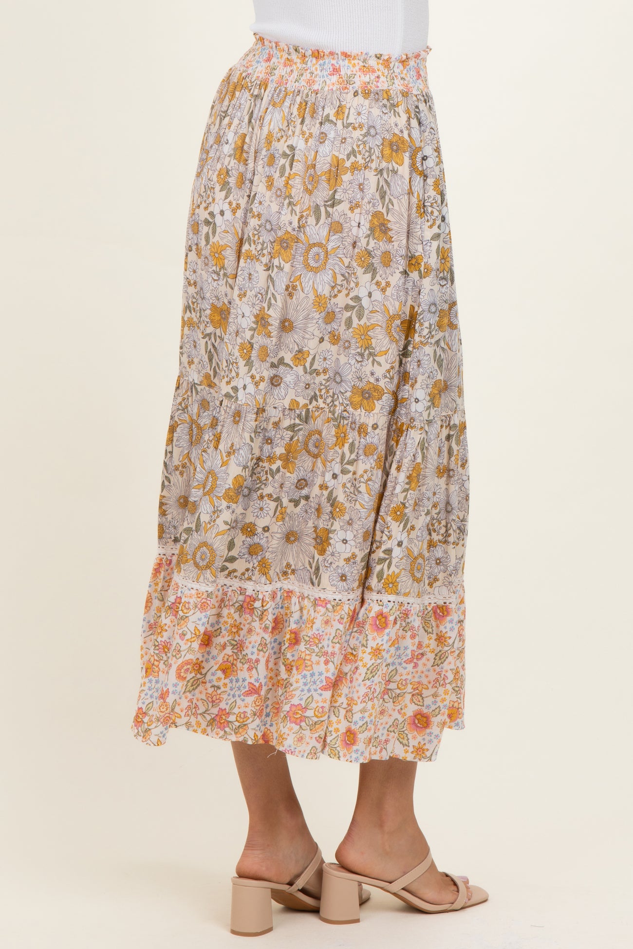 woman wearing a floral patterned maxi skirt with a ruffled hem and a colorful design