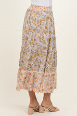 woman wearing a floral patterned maxi skirt with a ruffled hem and a colorful design